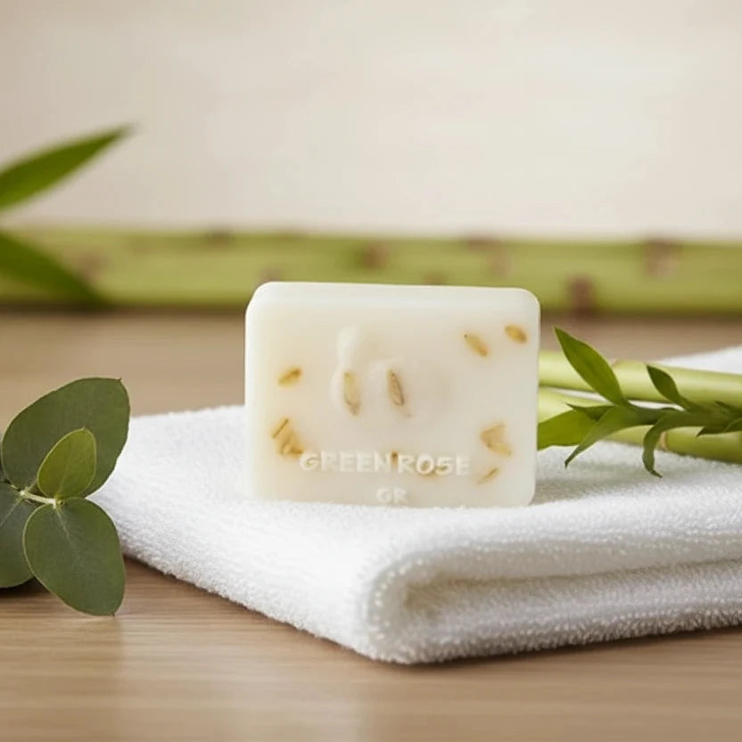 Bar of soap on a white towel with bamboo elements on a wooden surface